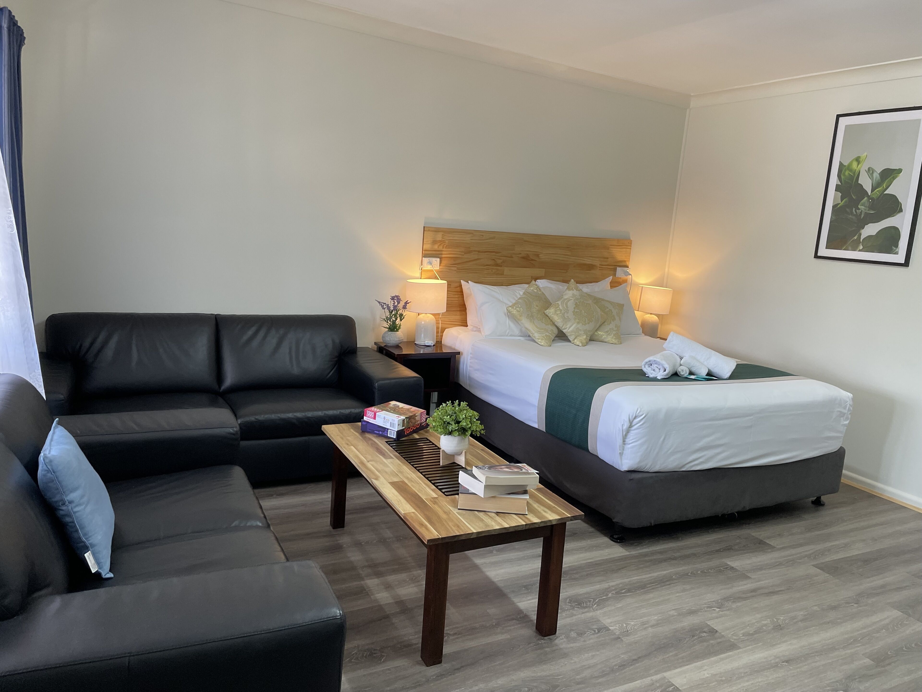 Une chambre d’hôtel avec un lit, un canapé, une petite table et une table de chevet.