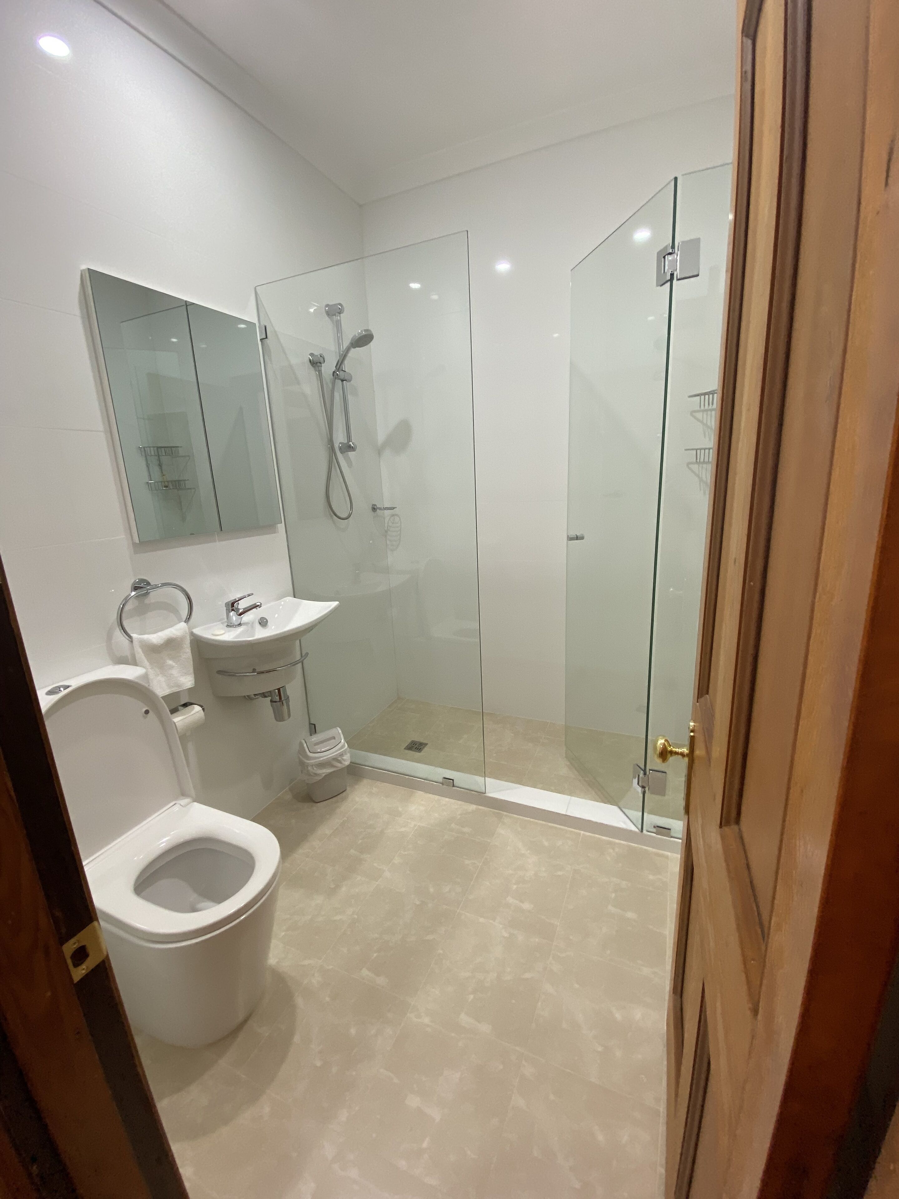 Un bagno moderno con toilette, lavandino e cabina doccia in vetro.