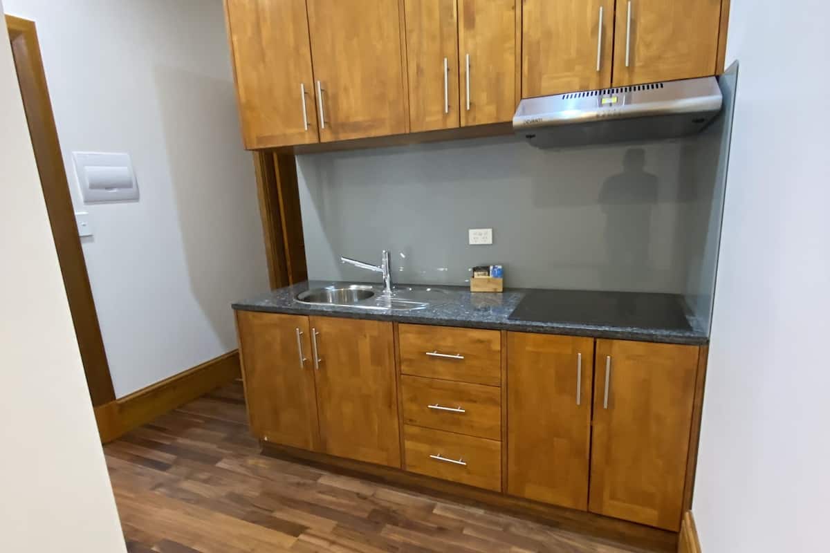 A kitchen with wooden cabinets, a stainless steel sink, and a built-in stove.
