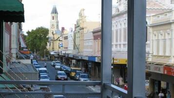 A street view with buildings, cars, and a clock tower.
