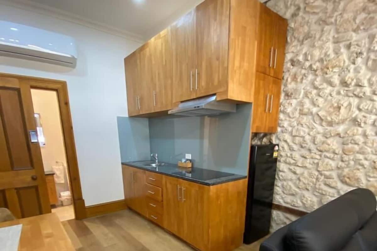 A compact living space with a kitchenette, a dining area, and a sofa.
