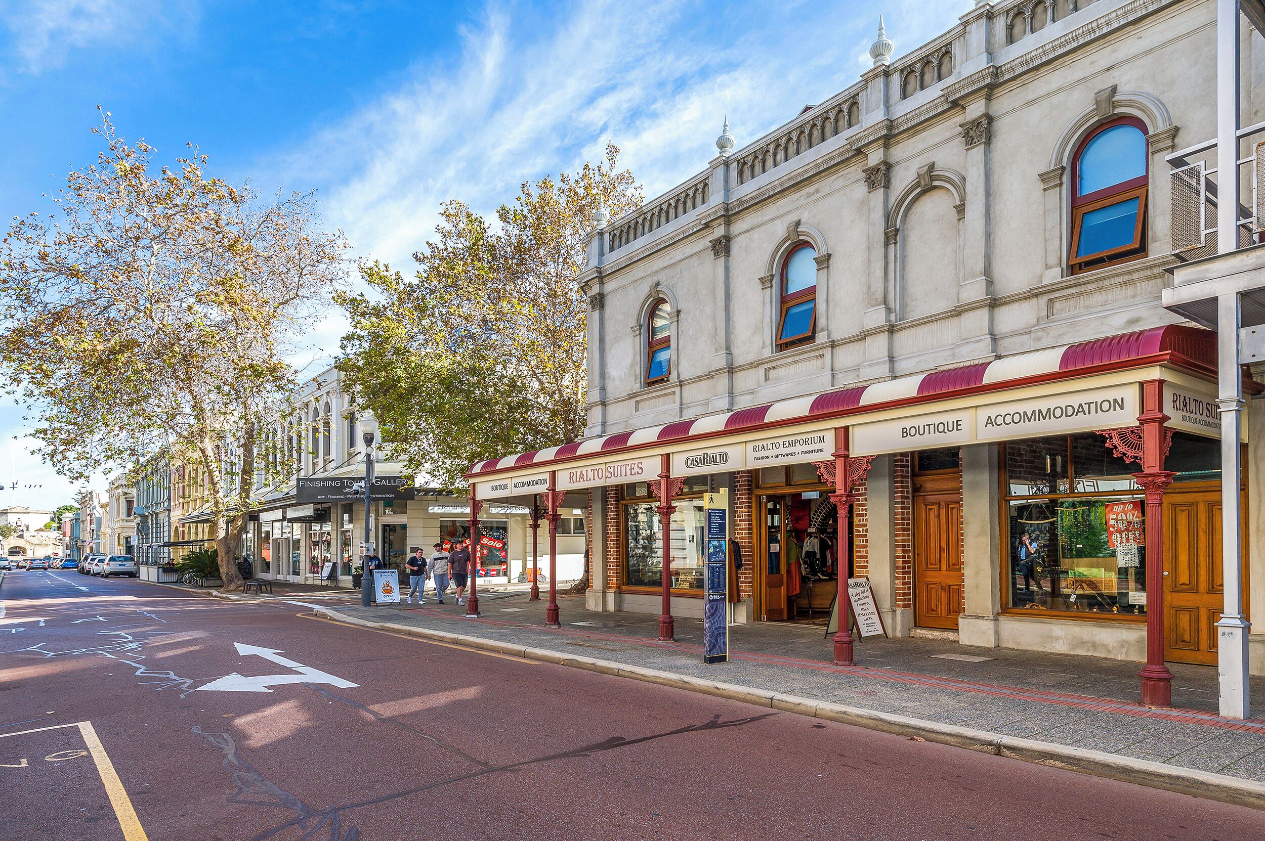 Una strada con negozi, tra cui una boutique e una galleria.