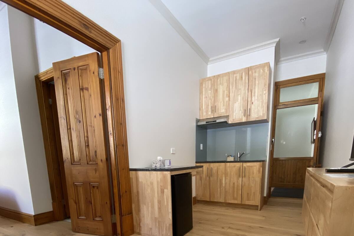 A spacious kitchen with wooden cabinets and a black countertop.