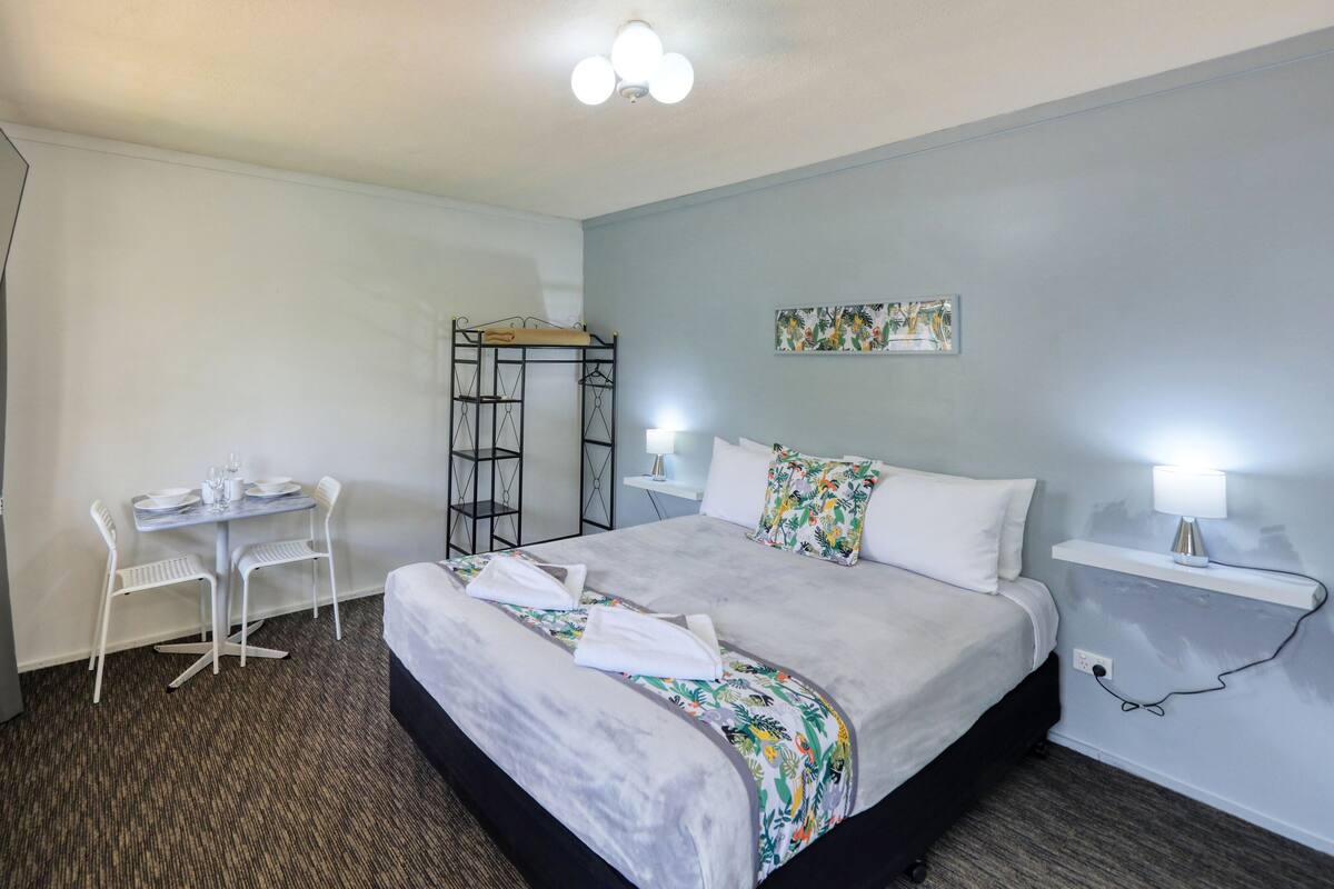 Une chambre d’hôtel avec un lit, un bureau et une chaise.