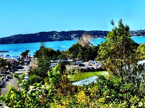 A coastal town with a marina, parked cars, and lush greenery. - Absolute Bliss (Paihia)