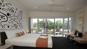 Habitación de hotel con dos camas, un ventanal grande, un ventilador de techo y vistas al exterior.