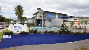 Un motel con piscina, un patio cubierto y un letrero que indica espacios de estacionamiento para discapacitados.