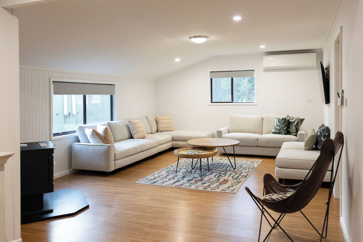 A modern living room with a sectional sofa, a round coffee table, and a leather chair.