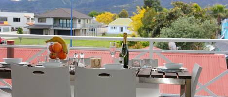 A table set for two with a bottle of champagne, a bowl of fruit, and a glass of wine.