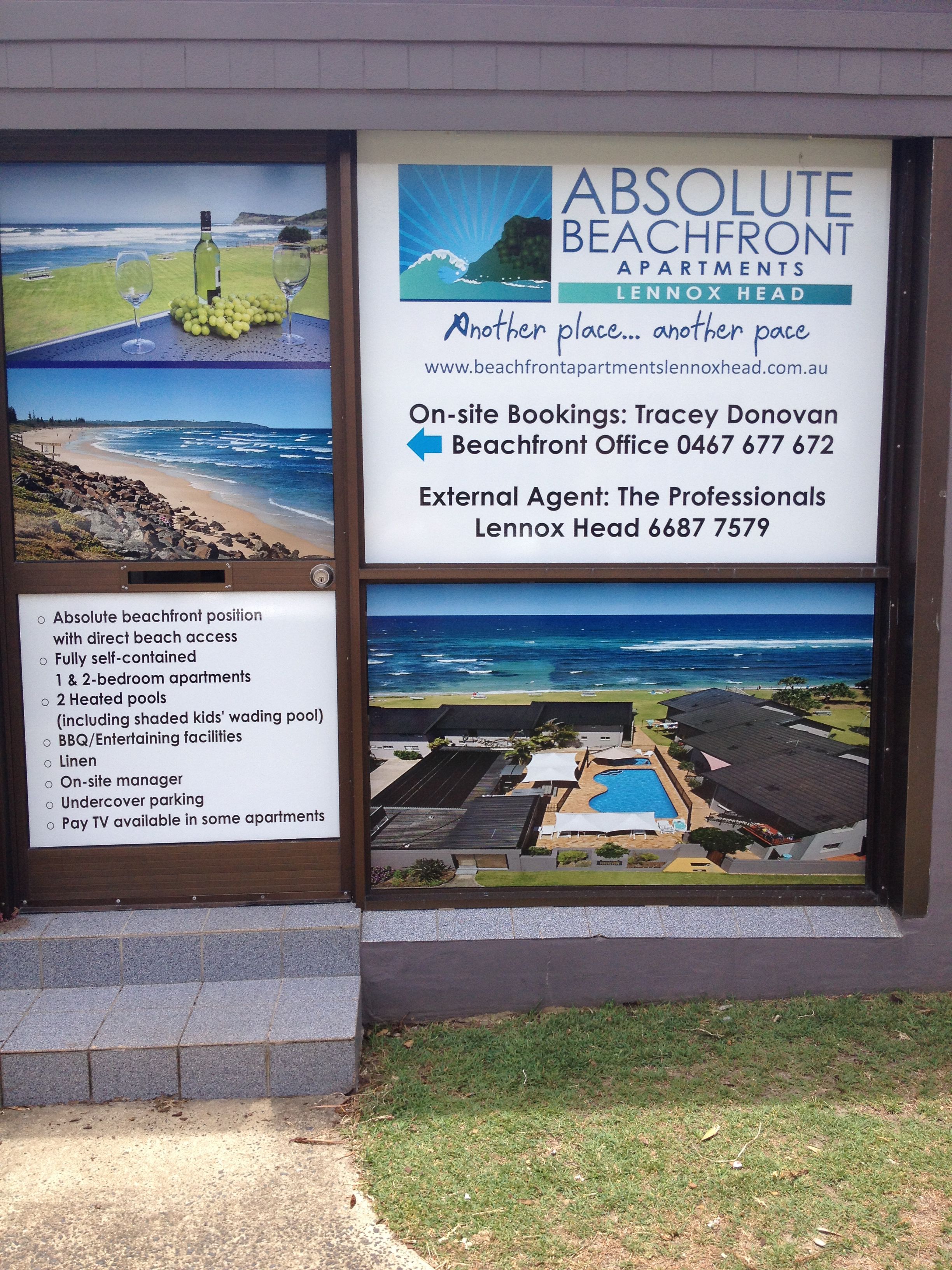 A sign for Absolute Beachfront Apartments in Lennox Head, featuring a beach view, amenities like heated pools, BBQ facilities, and a pay TV option.