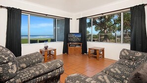 Ein Wohnzimmer mit Fernseher, zwei Sofas und einem Couchtisch.
