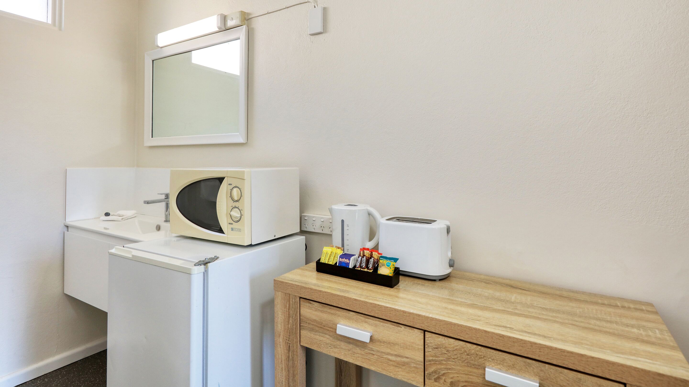 Une petite cuisine équipée d’un four à micro-ondes, d’un grille-pain, d’une bouilloire et d’un plateau de collations.
