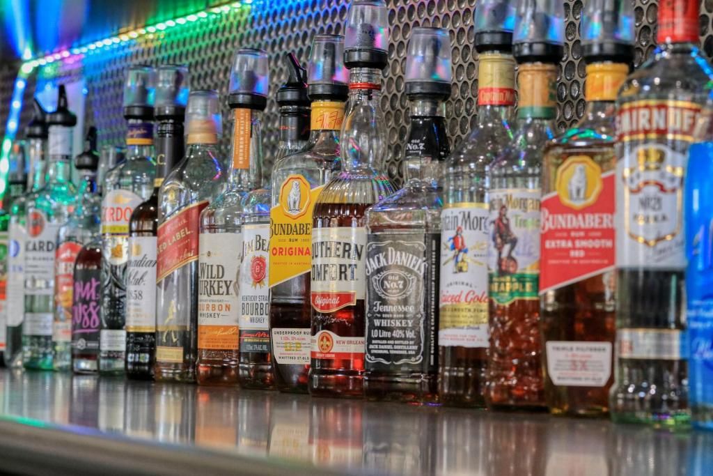 A variety of liquor bottles displayed on a shelf.