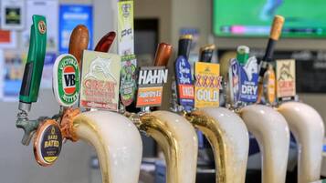 Una hilera de grifos de cerveza con diversas etiquetas de marca.