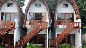 A modern house with a pool, featuring a unique architectural design with multiple balconies and wooden staircases. - Mojo Resort (Canggu)