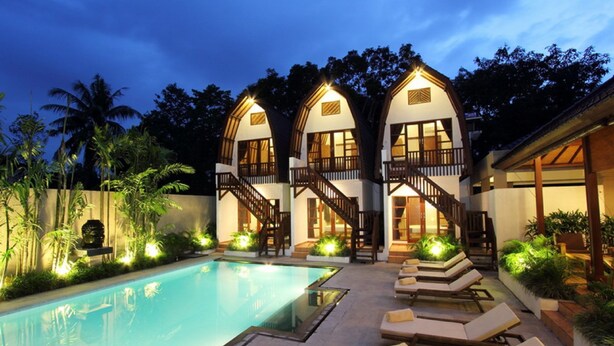 A two-story building with a swimming pool and lounge chairs. - Mojo Resort (Canggu)