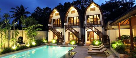 Alberca al aire libre y camastros