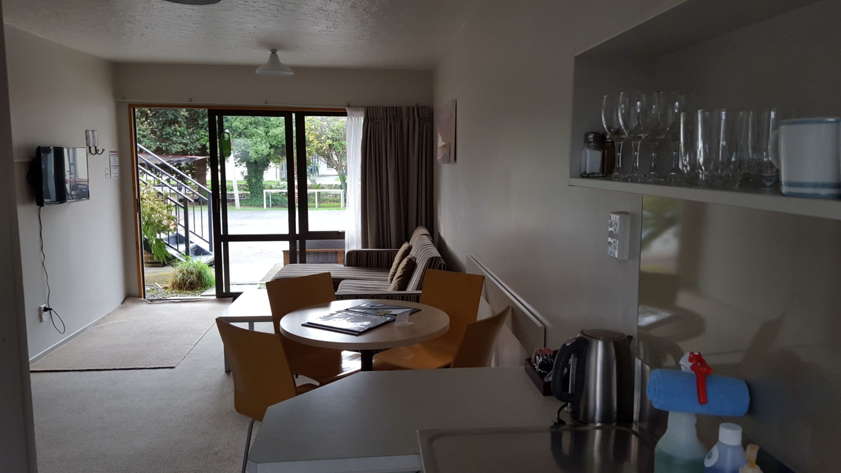 A compact living space with a dining area, kitchenette, and a view of the outdoors.