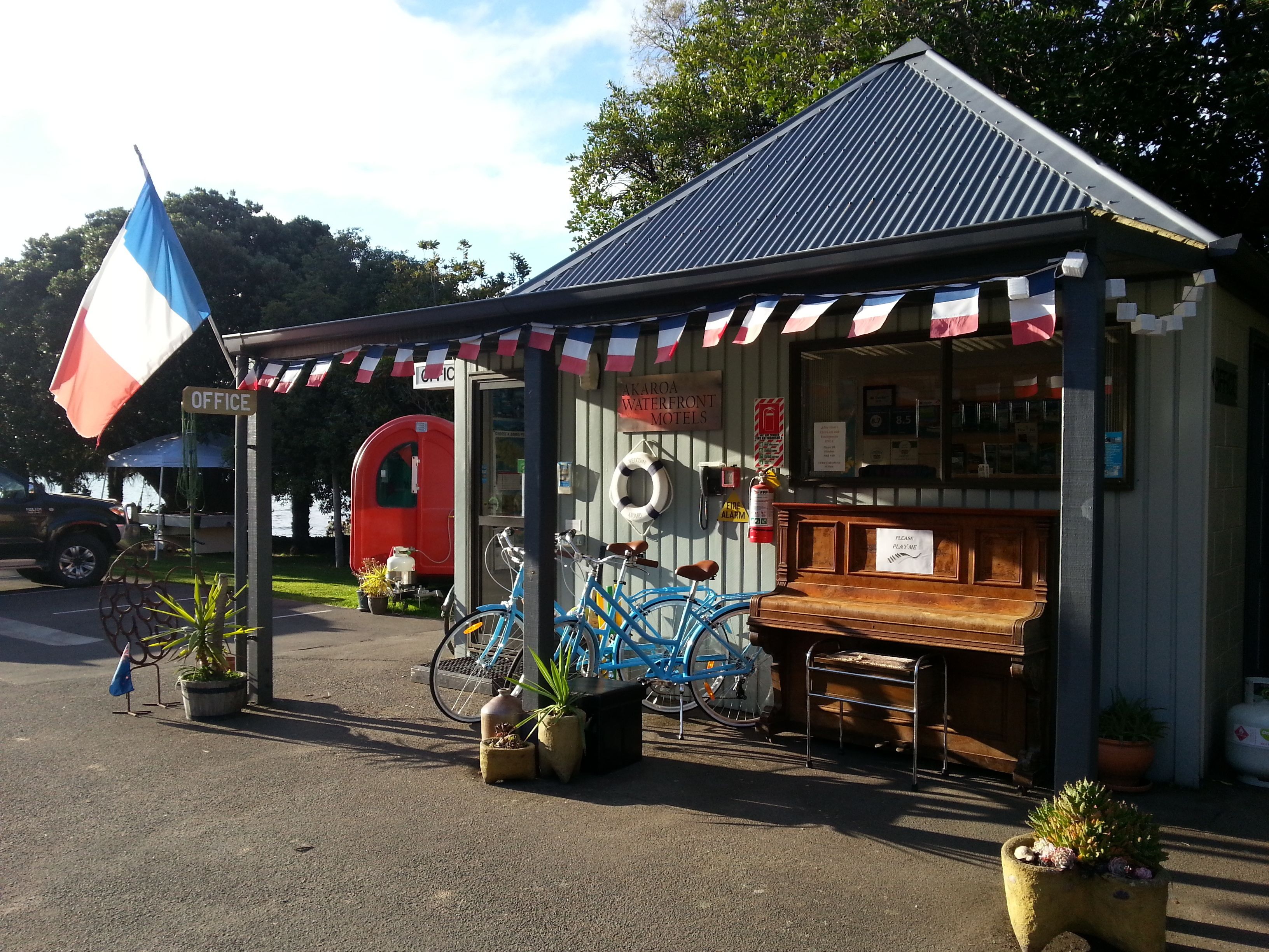 A small building with a sign reading "WATERFRONT MOTELS" and a flag.