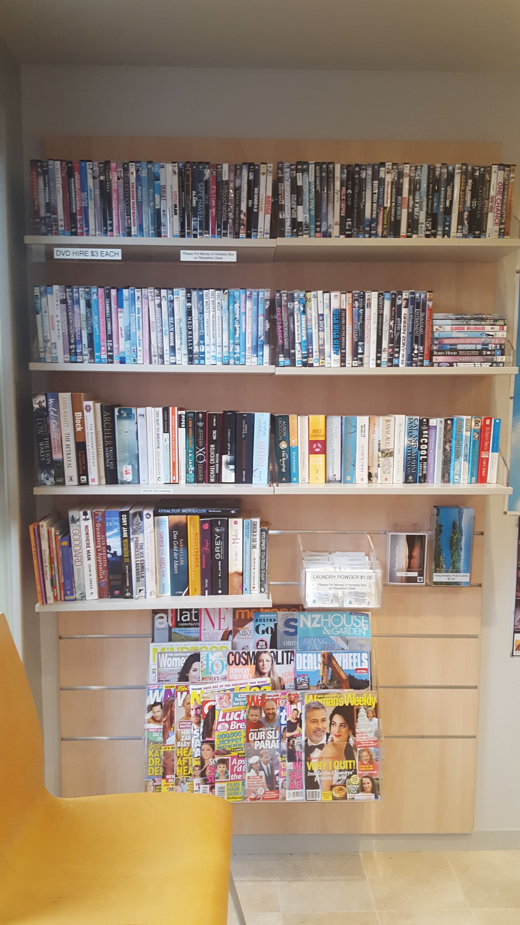 Una estantería con varios estantes llenos de libros y revistas.