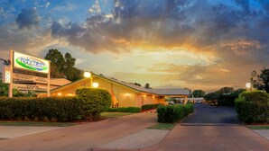 Un motel avec une enseigne indiquant qu’il propose une connexion Internet haut débit, un restaurant agréé et des chambres familiales.