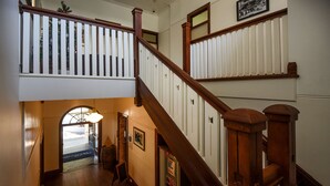 Una escalera de madera con barandillas blancas y vistas al nivel inferior.