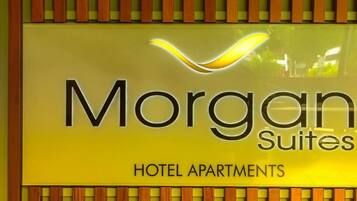 Une enseigne pour l’hôtel Morgan Suites, proposant des appartements, avec un design moderne et un logo.