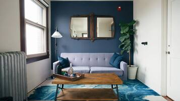 Chambre Deluxe | Coin séjour | Télévision à écran plat, lecteur de DVD, vidéothÚque