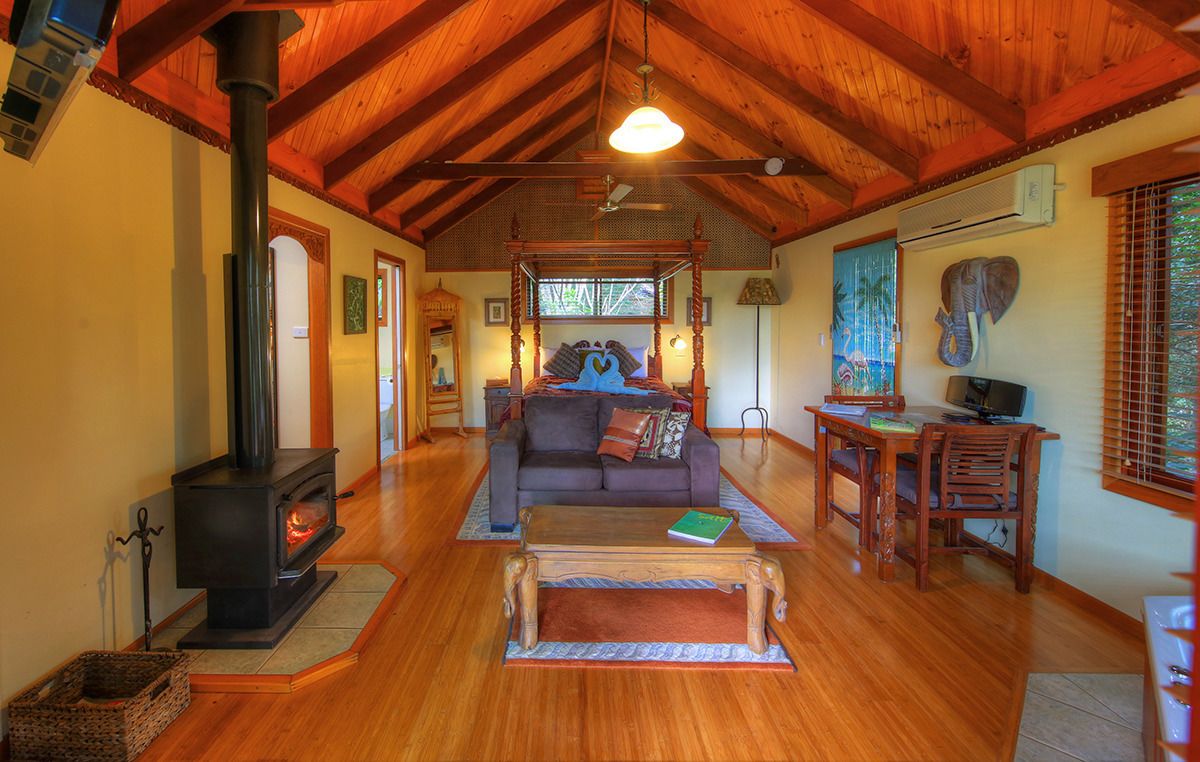A cozy living room with a fireplace, wooden furniture, and a comfortable sofa.