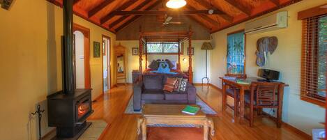 A cozy living room with a fireplace, wooden furniture, and a comfortable sofa.