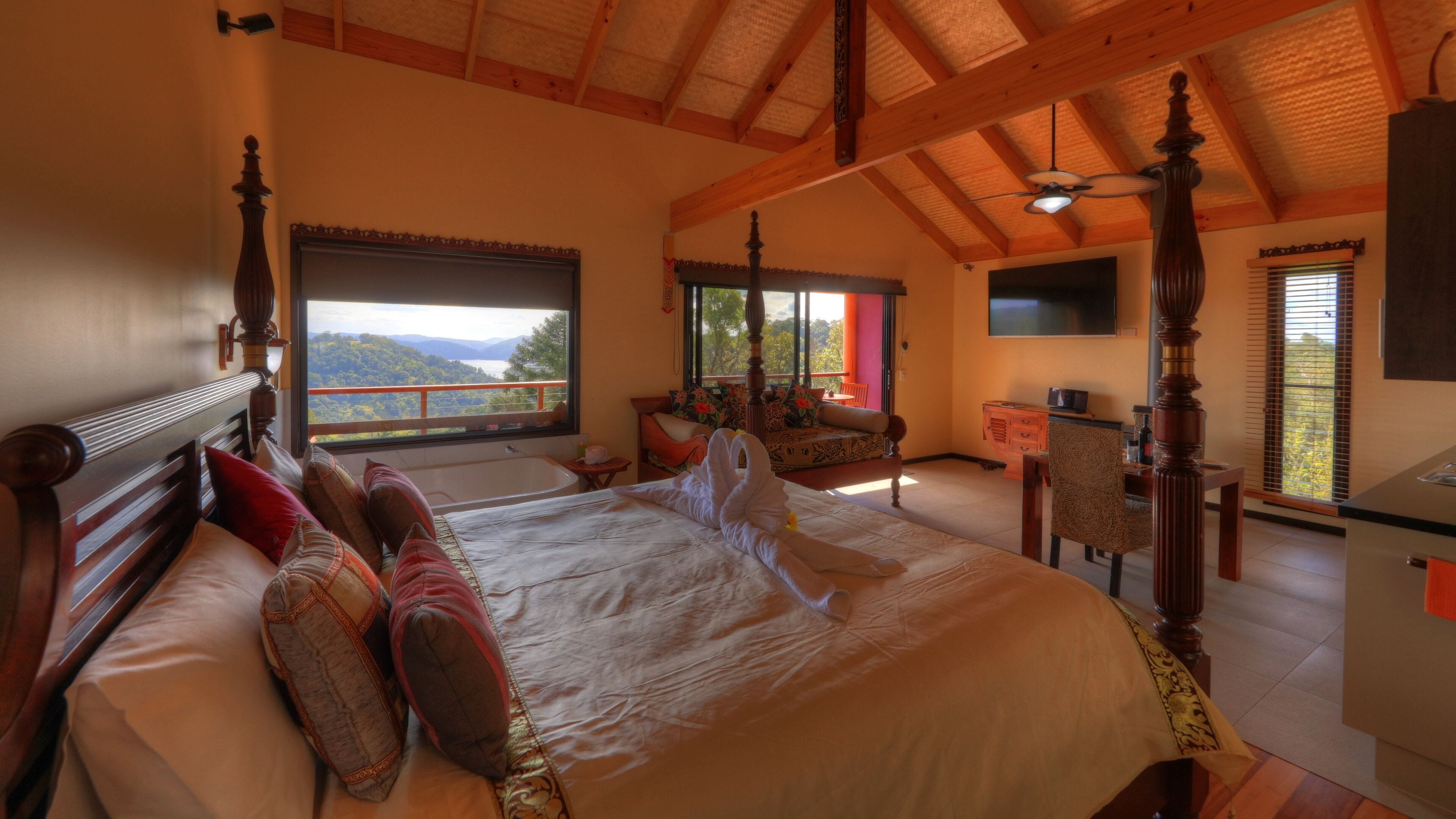 Un espacioso dormitorio con una cama grande, una sala de estar con vistas y un comedor con vistas.