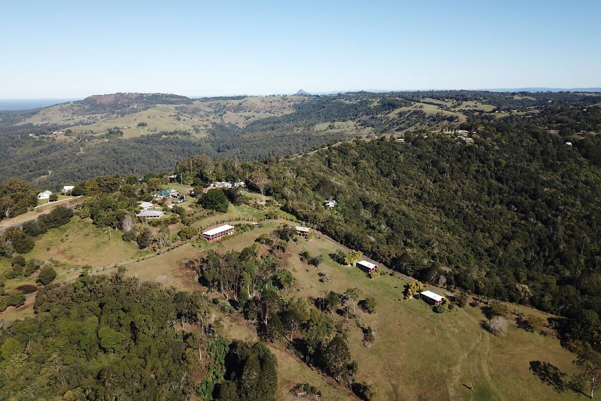 An aerial view of a rural landscape with scattered houses and dense forest.