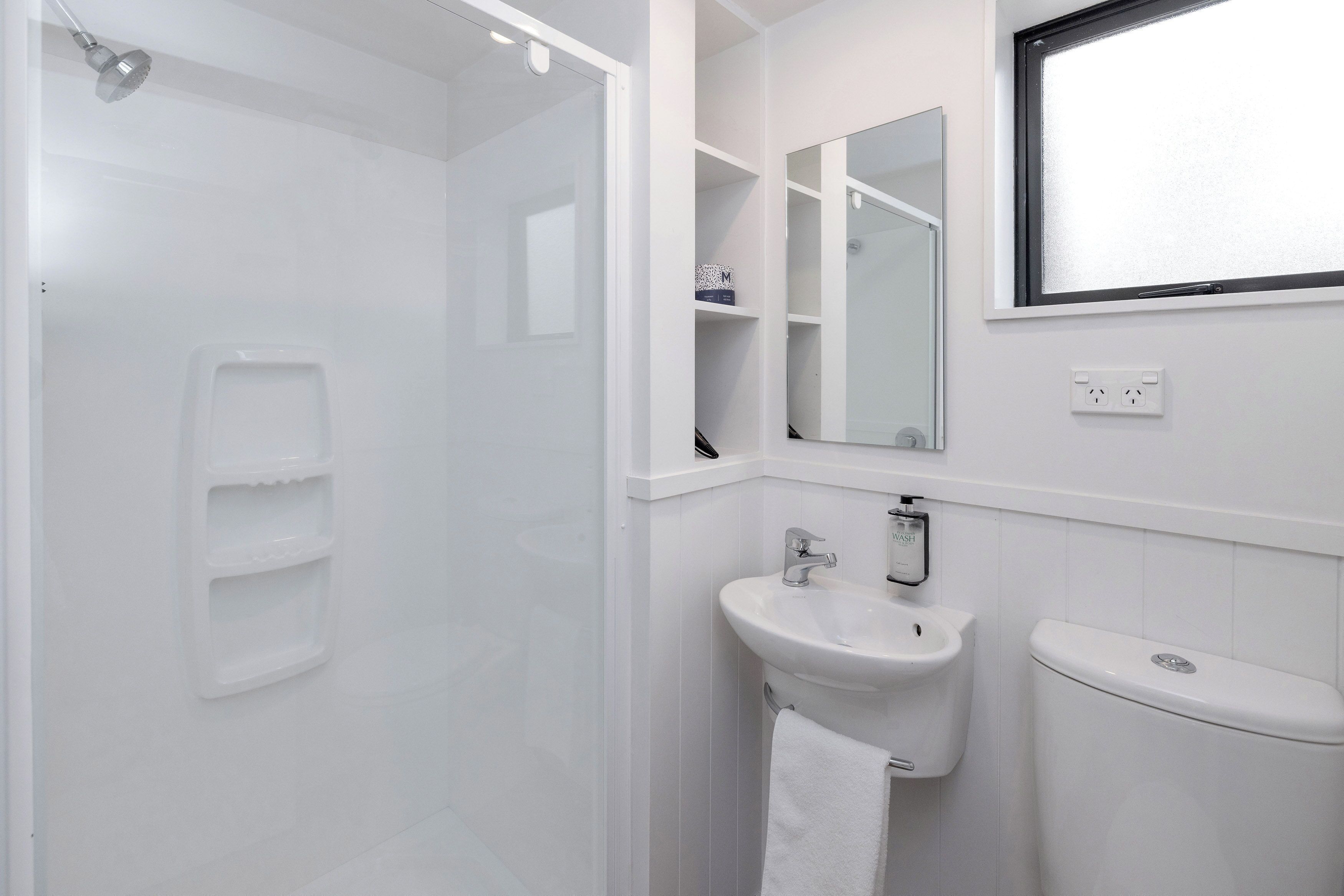 Une salle de bain moderne équipée d’une douche, d’un lavabo et de toilettes.