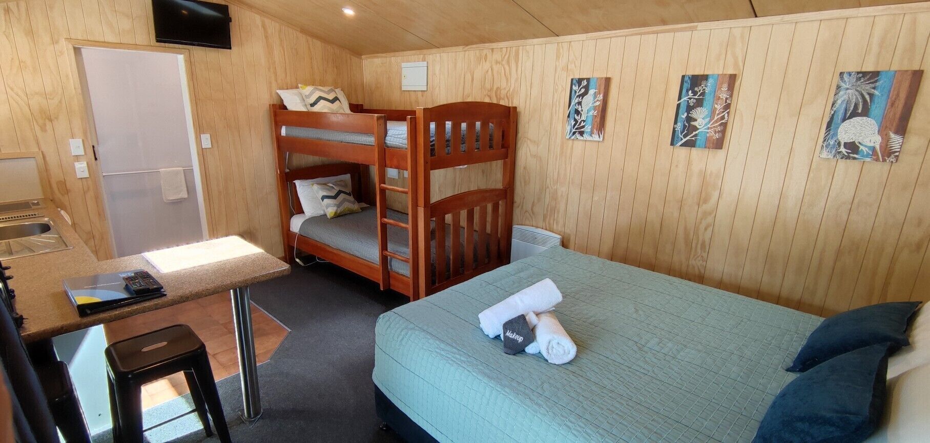 A bunk bed room with a desk and a bed.