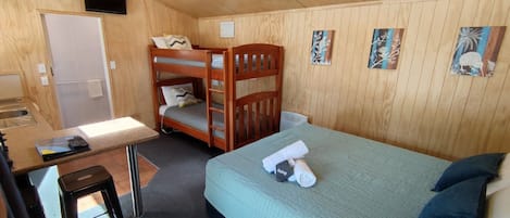 A bunk bed room with a desk and a bed.