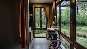 A modern bathroom with a large window, a sink, and a mirror. - Mountain Creek Golf Resort & Residences (Sikhio)