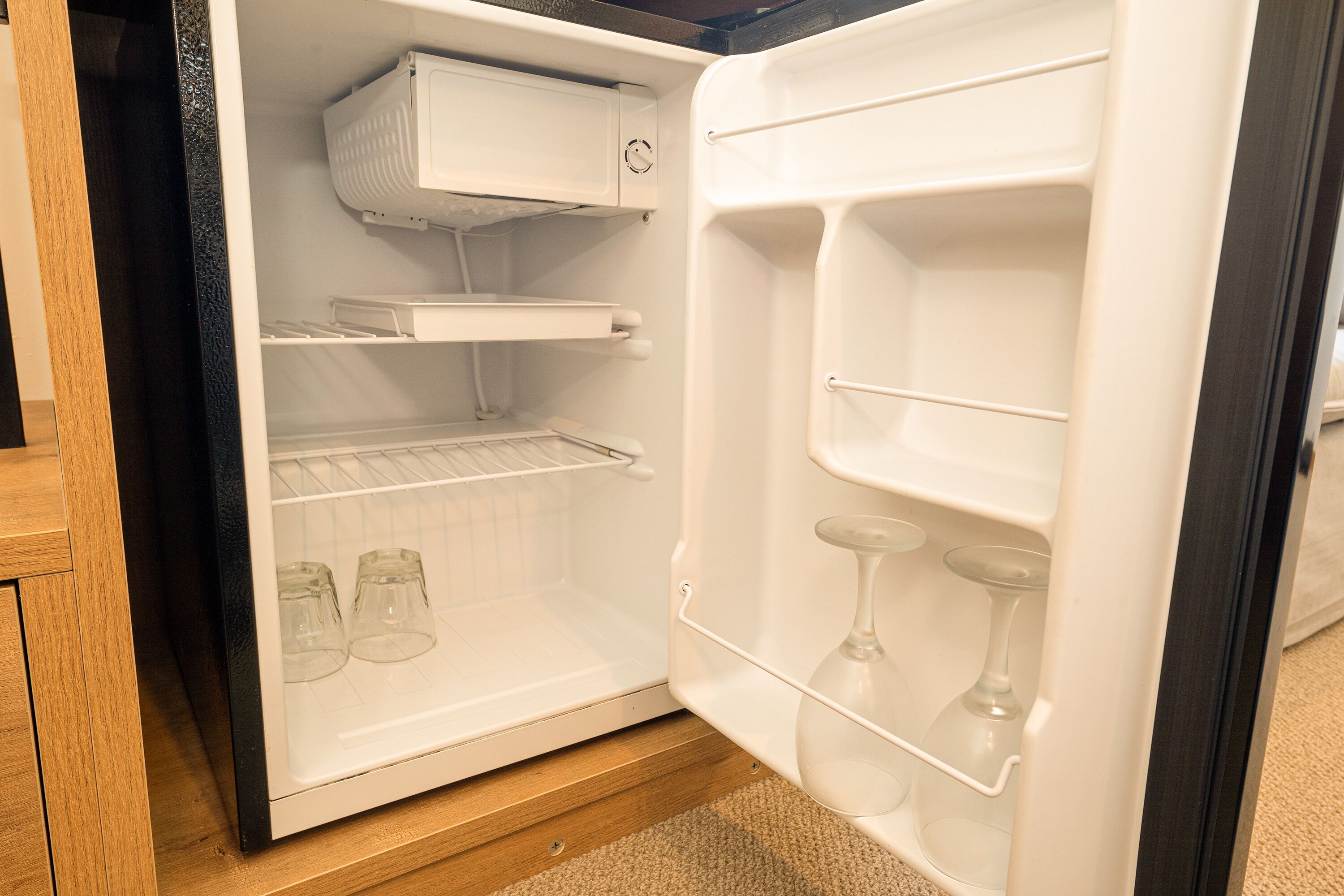 Un refrigerador obert amb prestatges i un compartiment congelador.