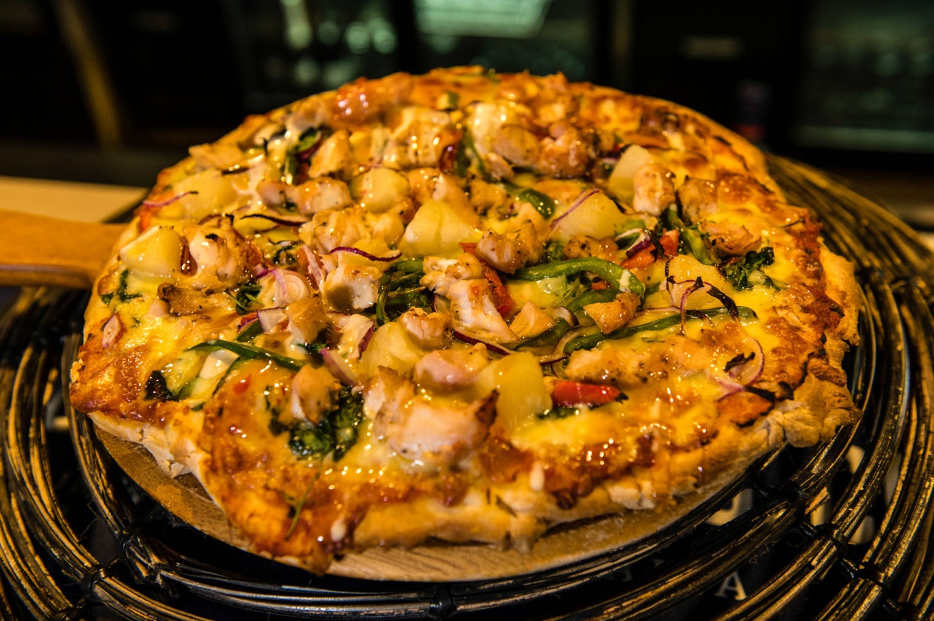 A pizza with various toppings on a black plate.