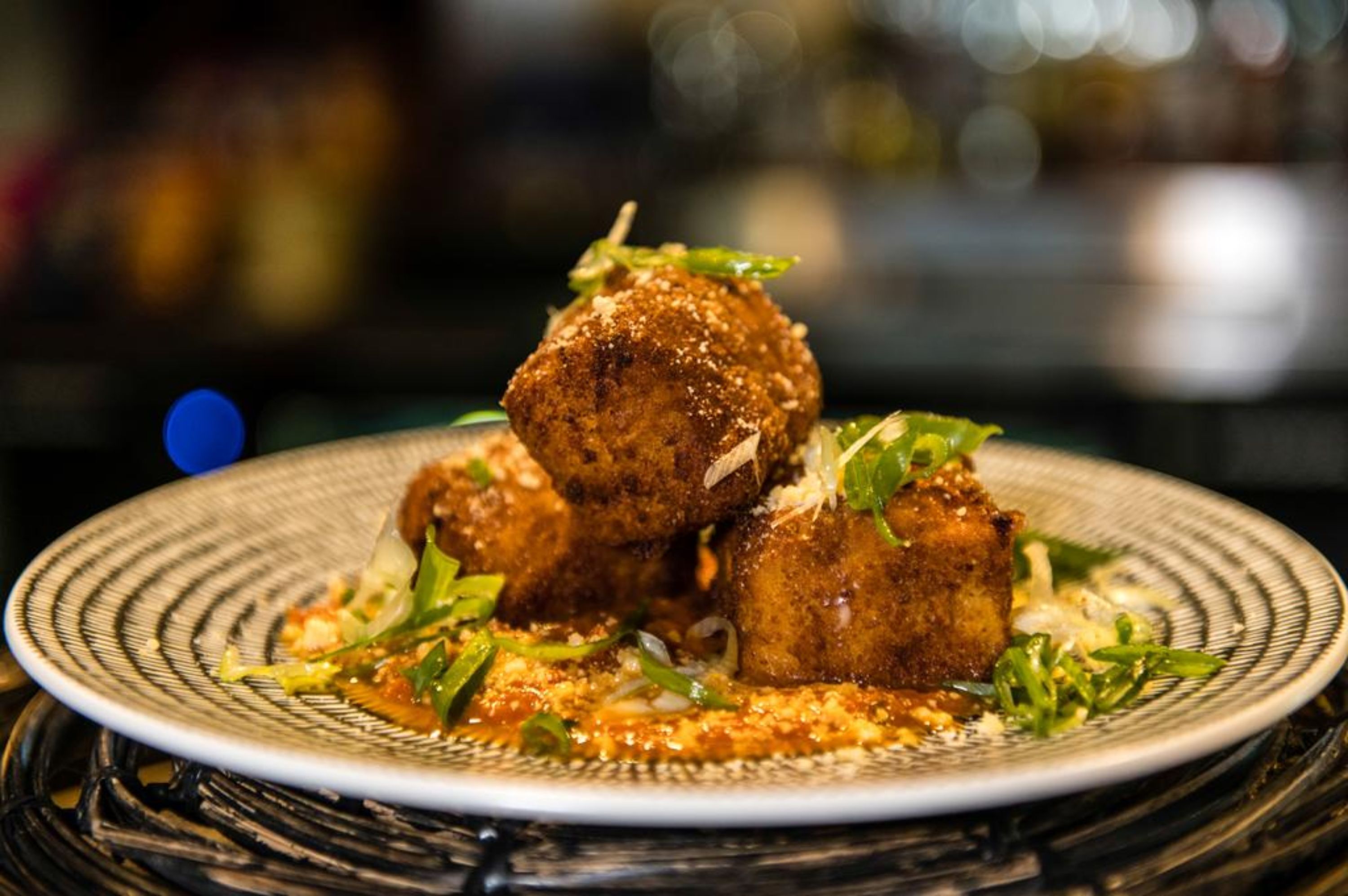 A plate of food with a textured rim and a dark, blurred background.