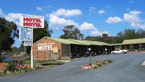 A motel with a signboard listing amenities like meals, breakfast, swimming pool, and TV. - Woomargama Village Hotel Motel (Woomargama)