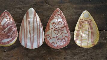 Vier decoratieve objecten met geometrische patronen op een houten ondergrond.