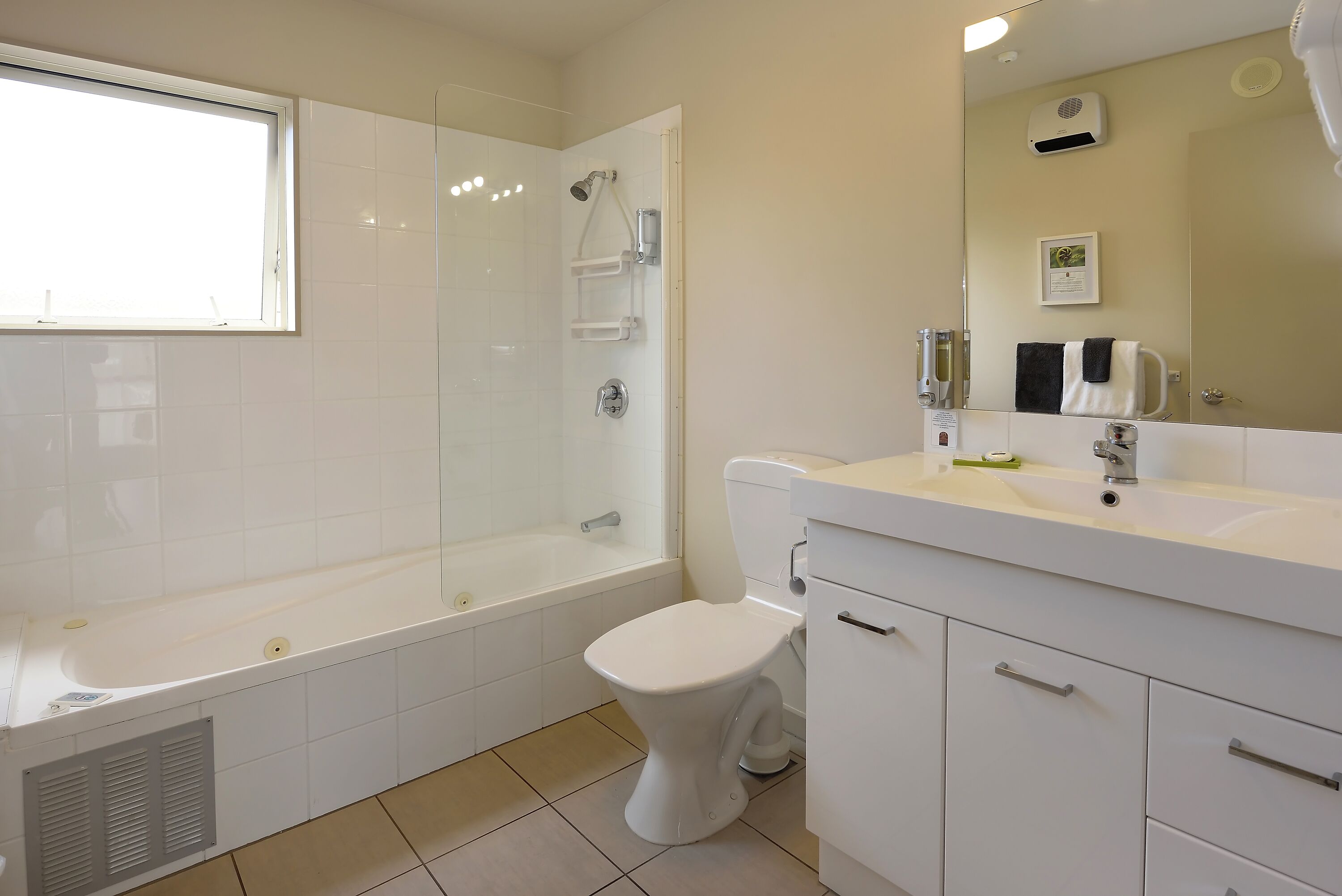 A modern bathroom with a bathtub, toilet, and vanity.