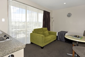 One Bedroom Standard Suite | Living area | 32-inch Smart TV with satellite channels, TV