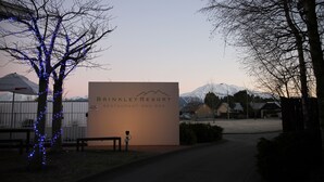A sign for Brinkle Resort Restaurant and Bar with a mountain backdrop.