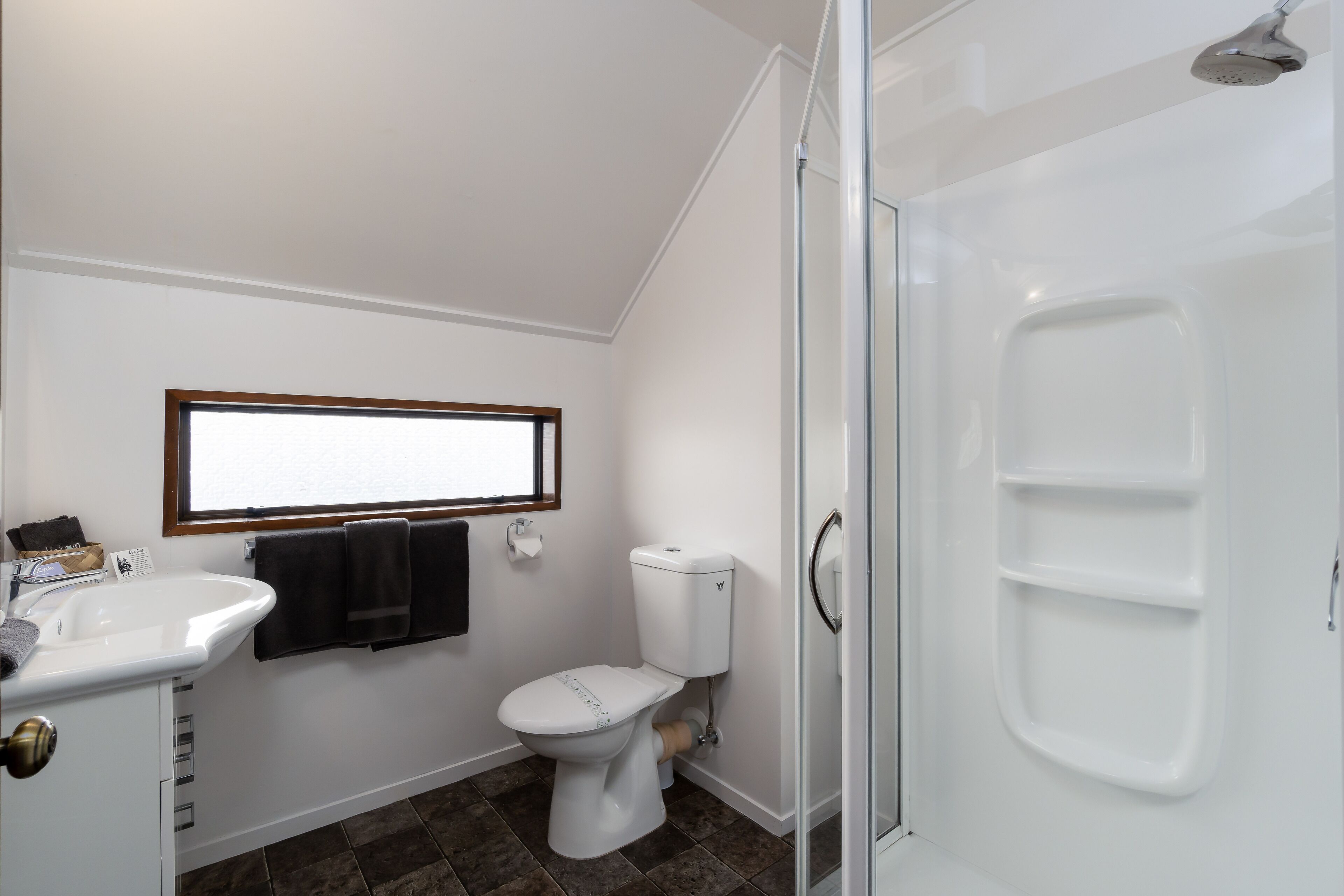 A bathroom with a white sink, toilet, and shower.