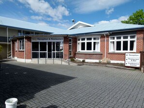 A reception and restaurant building with a brick facade, large windows, and a sign indicating directions to the reception, restaurant, and conference center.