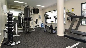 A gym with cardio machines, weightlifting equipment, and a treadmill. - City West Accommodation (Perth)