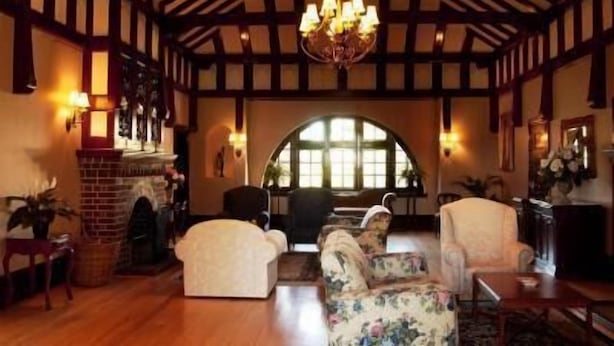 A traditional interior with exposed wooden beams, a fireplace, and a chandelier. - Petersons Armidale Winery & Guesthouse (Armidale)