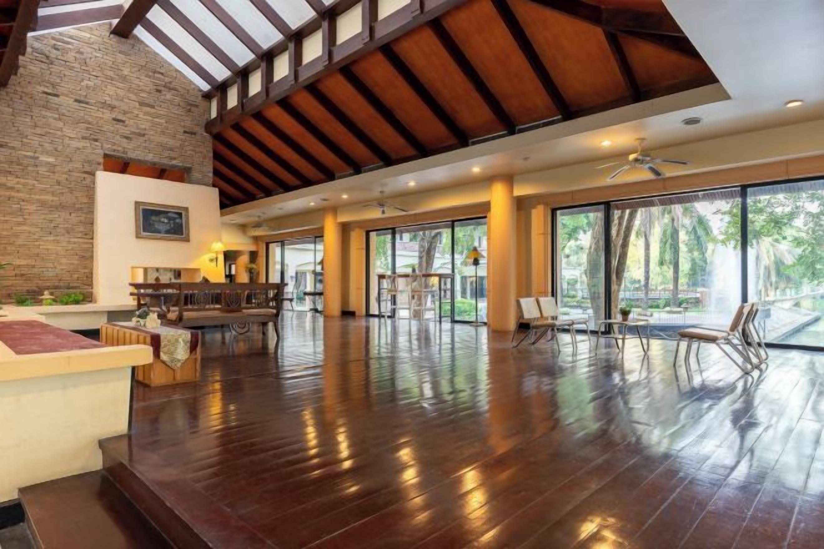 A spacious indoor area with a high ceiling, wooden beams, and a large open space with a polished floor.
