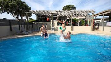 Una piscina al aire libre, tumbonas